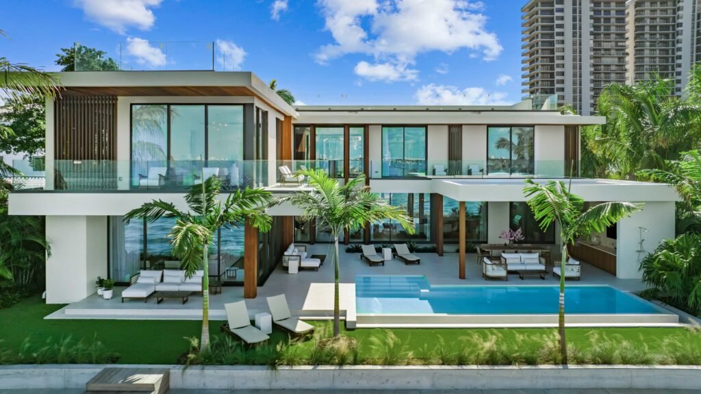 F1 star Eddie Irvine lists his £27.6m Miami waterfront mansion with 6 bedrooms, rooftop terrace, theatre, pool and 360° views of Biscayne Bay and the city skyline.