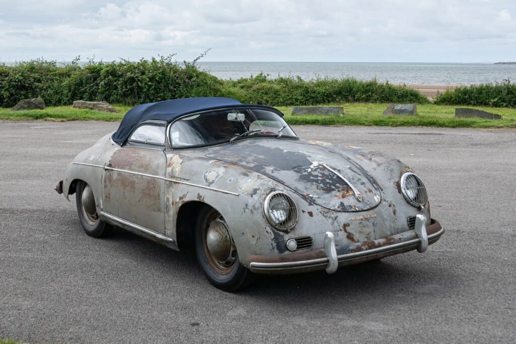 A rare 1955 Porsche 356 Pre-A Speedster, discovered rusting on an Ohio farm after 70 years, sold for £393,750 at auction as a preservation-class barn find gem.